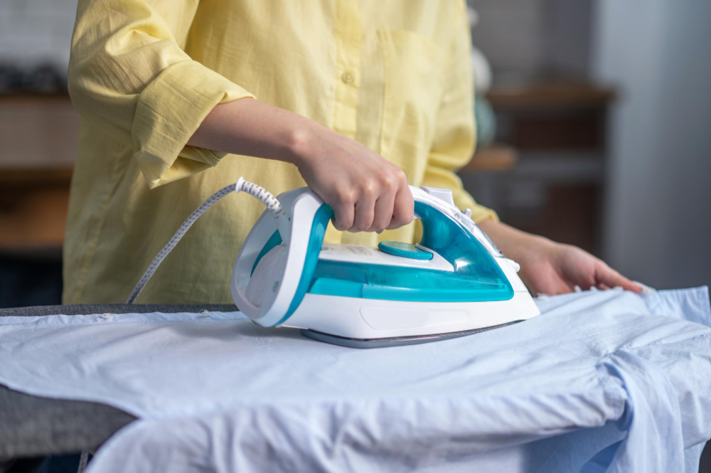 female-hands-ironing-wrinkled-clothes-ironing-board
